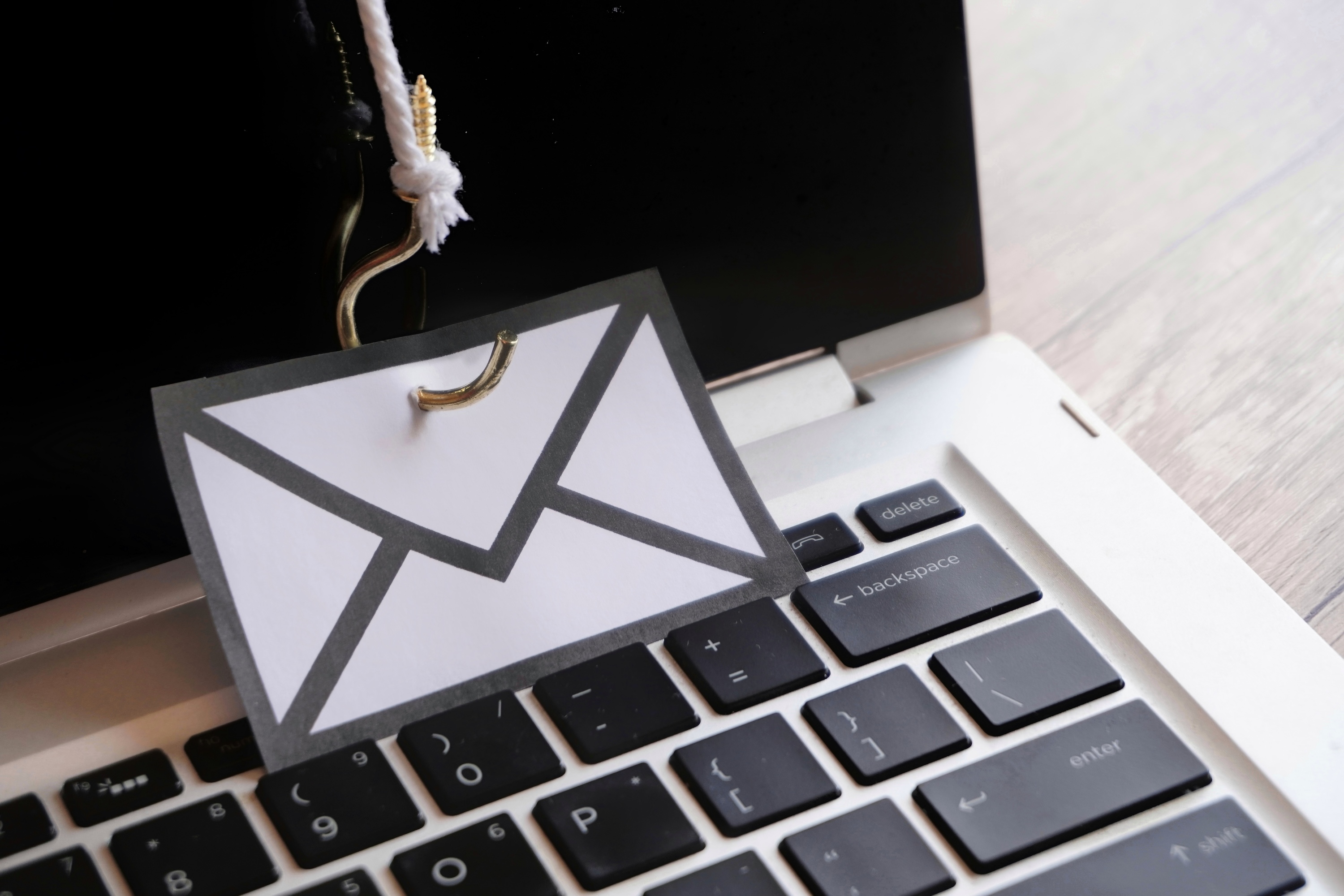 closeup-image-of-mail-with-hook-on-top-of-keyboard-2025-03-14-03-15-35-utc Closeup image of mail with hook on top of keyboard. Phishing email, malware and cyber security concept