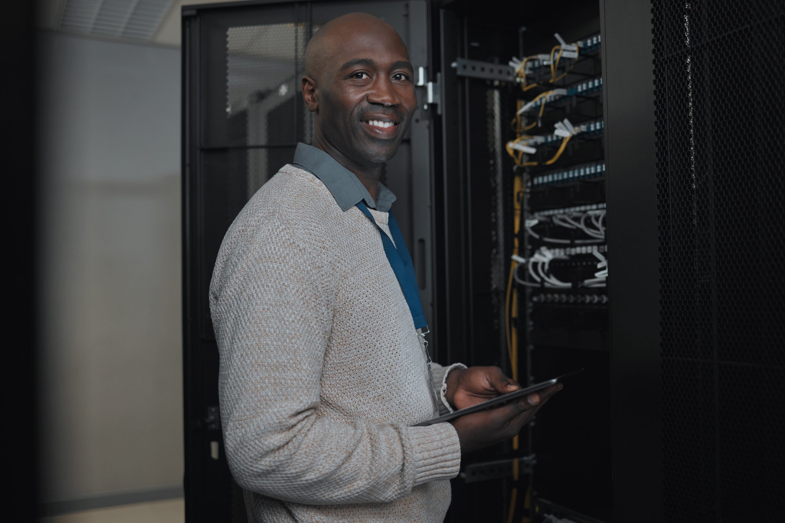Portrait, server room and IT black man on tablet for database connection cable, maintenance or soft.