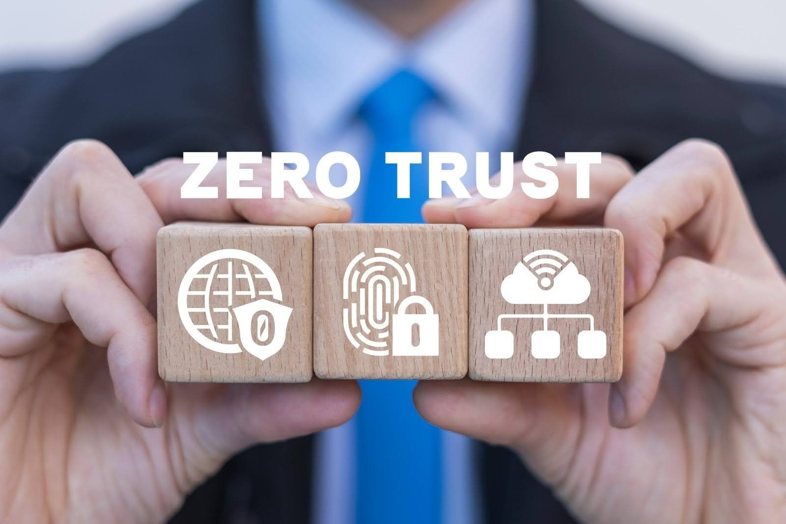 A person holds three wooden blocks with icons for internet security, fingerprint lock, and cloud network under the text "ZERO TRUST," representing the core principles of a zero trust network. Beyond the Castle Walls: Understanding Zero Trust Networks
