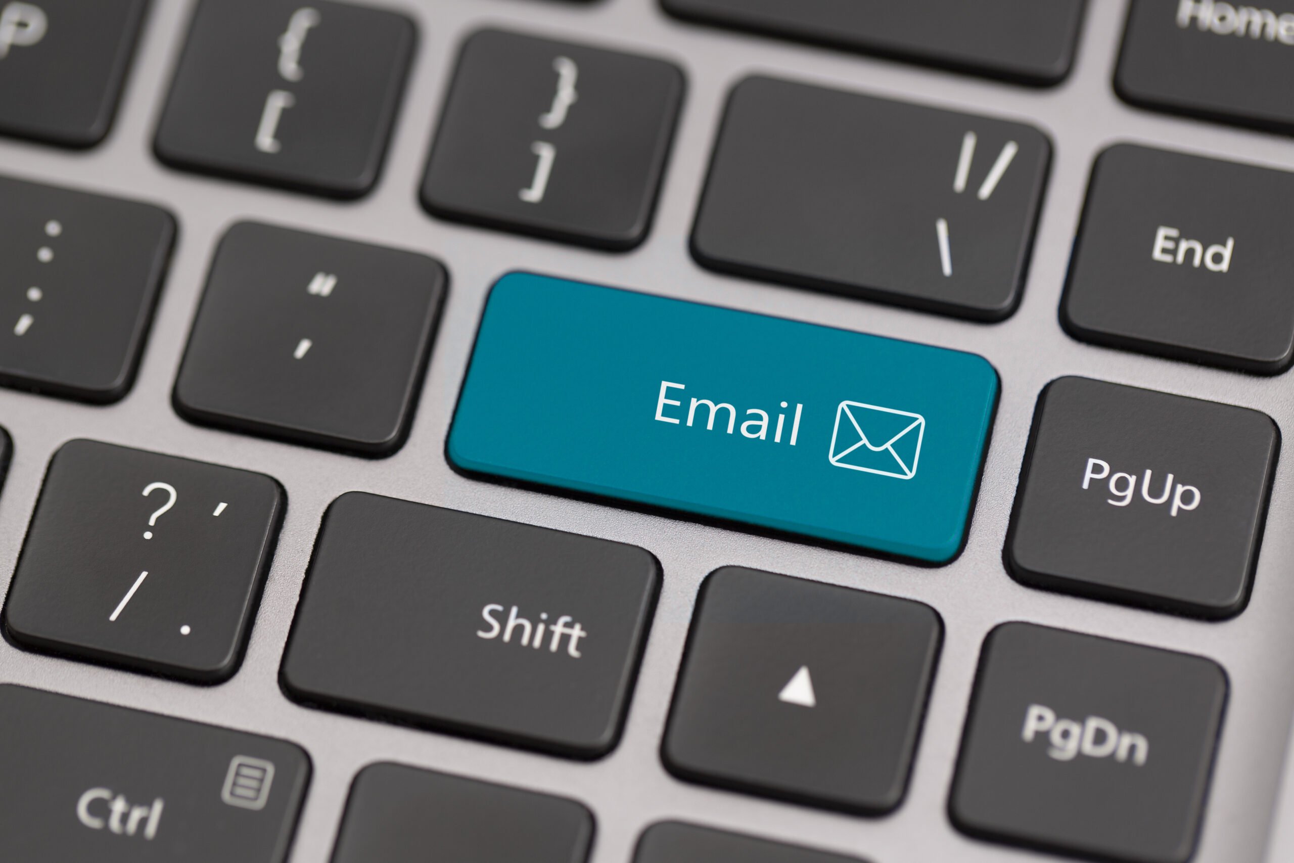 A close-up of a computer keyboard with a blue "Email" key that features an envelope icon, surrounded by standard black keys.