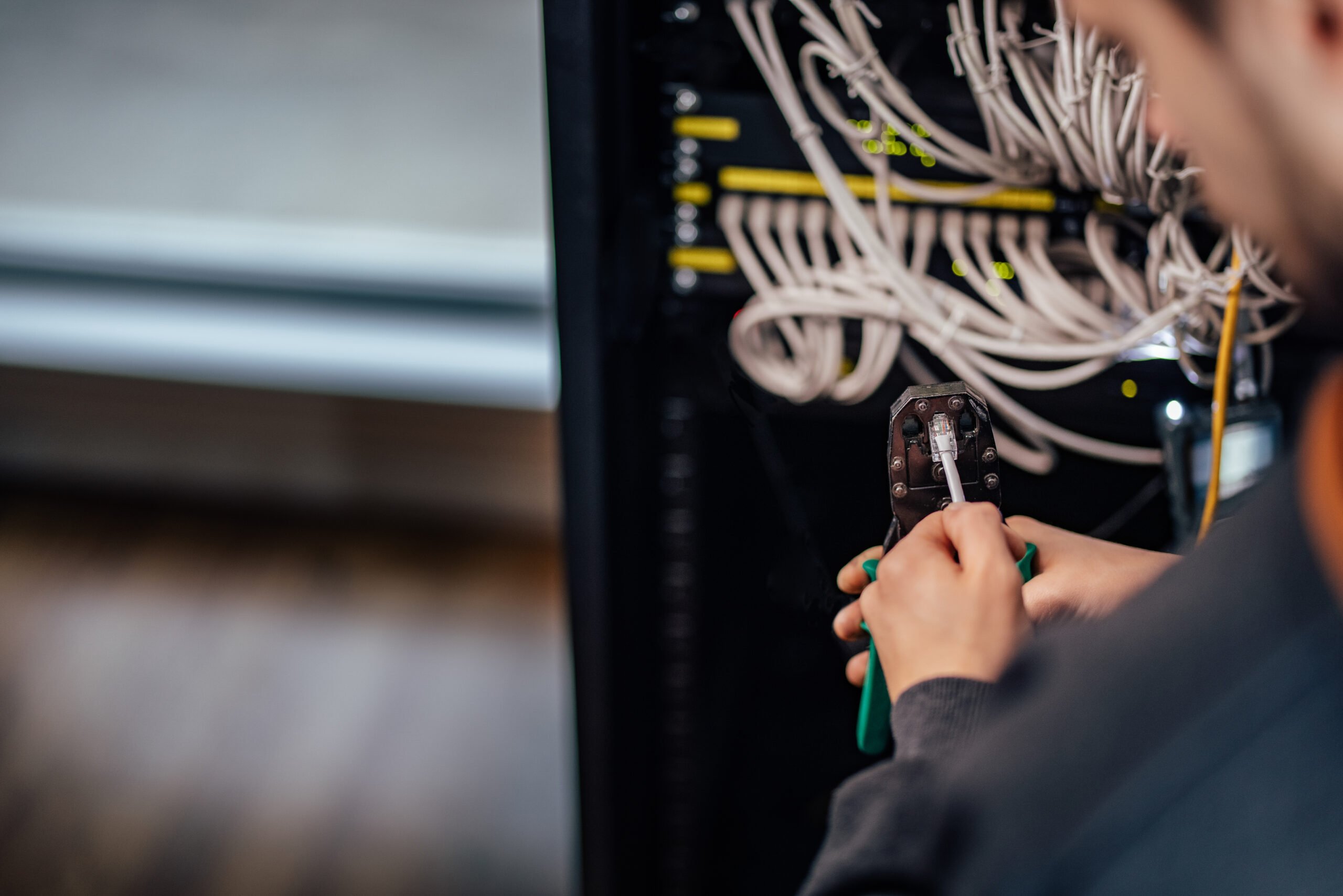 Setting up a network. Crimping connector with network tool kit, close--up.